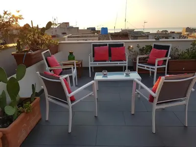 a patio with chairs and tables on a roof at Malusi B&B in Sferracavallo