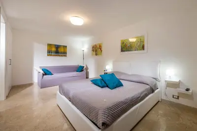 a bedroom with a bed and a couch at Le Case di Katy in Castellammare del Golfo