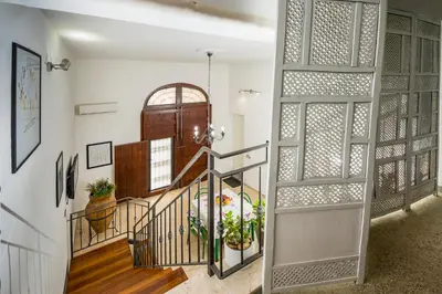 a hallway with a spiral staircase with a wooden door at Le Case di Katy in Castellammare del Golfo