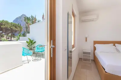 a bedroom with a bed and a balcony at Zizha Suite sul mare - San Vito Lo Capo in San Vito lo Capo