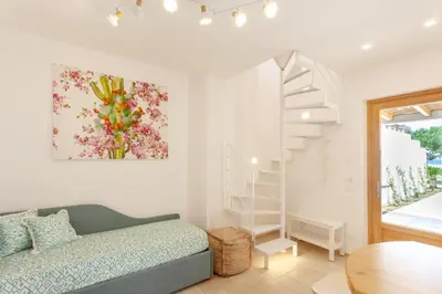 a bedroom with a bed and a stair case at Zizha Suite sul mare - San Vito Lo Capo in San Vito lo Capo