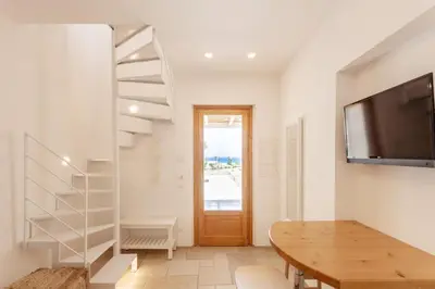 a living room with a wooden table and a tv at Zizha Suite sul mare - San Vito Lo Capo in San Vito lo Capo