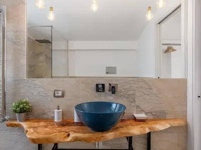 a bathroom with a large blue bowl sink on a wooden counter at Holiday Home Quirat by Interhome in Terrasini