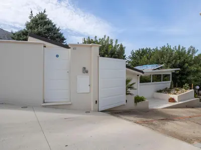 a white house with white doors on a driveway at Holiday Home Quirat by Interhome in Terrasini