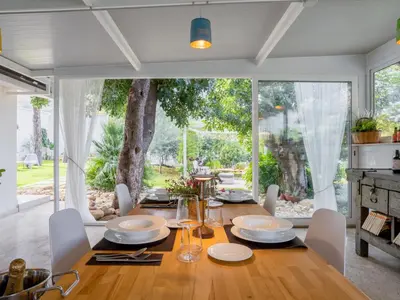 a dining room with a table and a large window at Holiday Home Quirat by Interhome in Terrasini