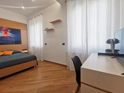 a bedroom with a bed and a desk with a computer at Maqueda Mood in Palermo