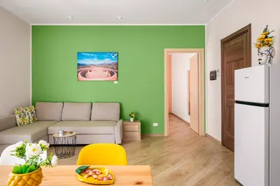 a living room with green walls and a table and chairs at Kalatafimi- Palermo Apartment 2 Camere & Wi-Fi in Palermo