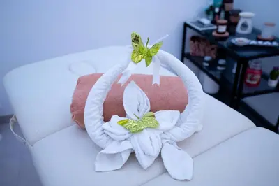 a cake with white towels and flowers on it at B&B il Colibrì in San Vito lo Capo