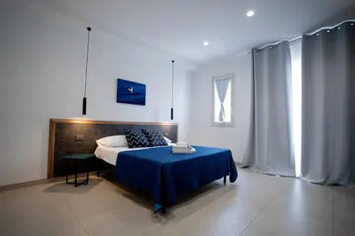 a bedroom with a bed and a blue table at B&B il Colibrì in San Vito lo Capo
