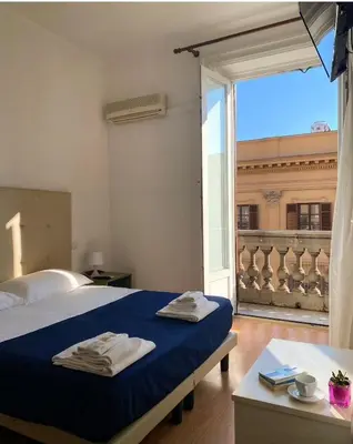 a bedroom with a bed and a large window at 38 Aira Hotels in Palermo