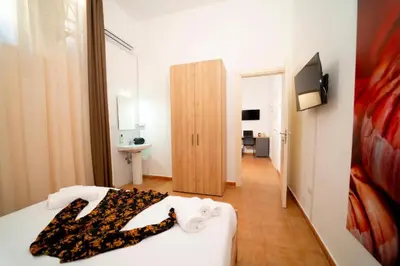 a bedroom with a bed with a black and white scarf on it at Ballaro' Hotel - Budget Room in Palermo