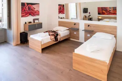 a bedroom with two beds and a mirror at Ballaro' Hotel - Budget Room in Palermo