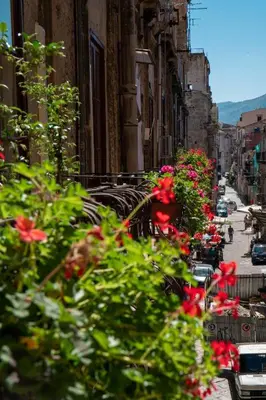a street with flowers on the side of buildings at Ballaro' Hotel - Budget Room in Palermo