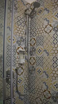 a shower in a bathroom with a tile wall at La Casa Dei Leoni Di Sicilia in Palermo