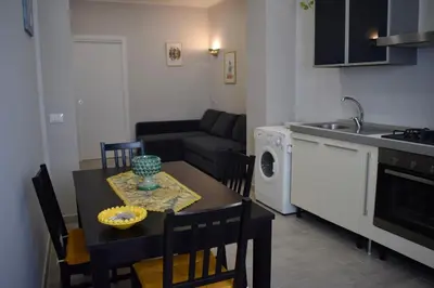 a kitchen and living room with a table and a kitchen and a dining room at La Casa Dei Leoni Di Sicilia in Palermo