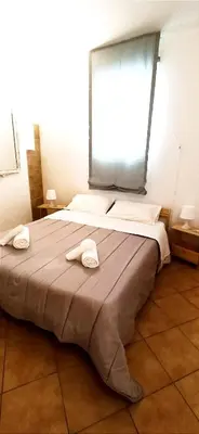 a bedroom with a large bed with two towels on it at Ai Normanni in Palermo