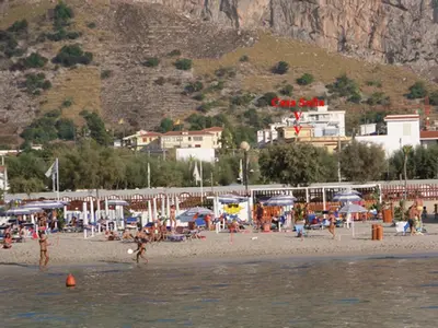 a group of people on a beach near the water at Leonardo in Capaci