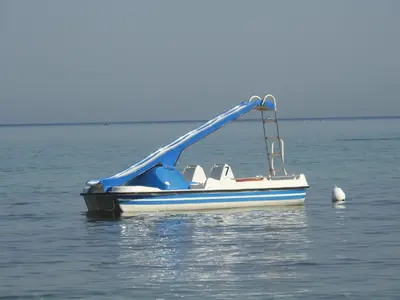 a blue and white boat sitting in the water at Leonardo in Capaci