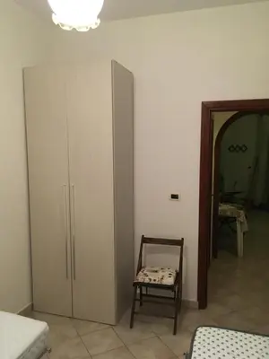a room with a large cabinet and a chair at Leonardo in Capaci
