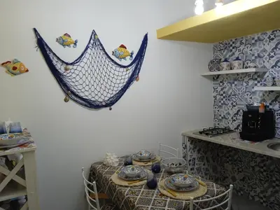 a room with a table with a hammock on the wall at Mary Gery's Rooms in Castellammare del Golfo