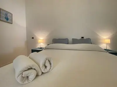 a bedroom with a white bed with towels on it at Catarin Comfort Rooms in Castelluzzo