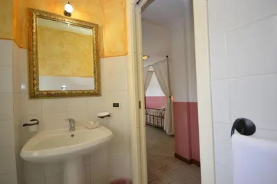 a bathroom with a sink and a mirror at Catarin Comfort Rooms in Castelluzzo