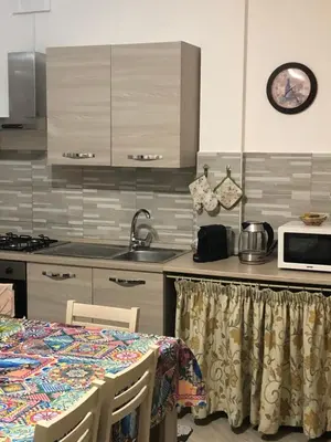 a kitchen with a table and chairs in a room at Casa Donatella a Isola in Isola delle Femmine