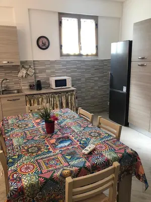 a bedroom with two beds and a chair and a window at Casa Donatella a Isola in Isola delle Femmine