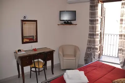 a bedroom with a desk and a bed and a desk and chair at La casa del custode in Caccamo