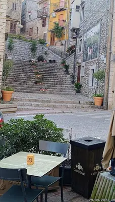 a table and chairs in front of some stairs at La casa del custode in Caccamo