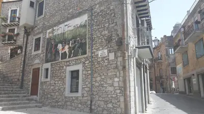 a stone building with paintings on the side of it at La casa del custode in Caccamo