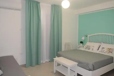 a bedroom with a bed and green curtains at I colori del mare in Macari