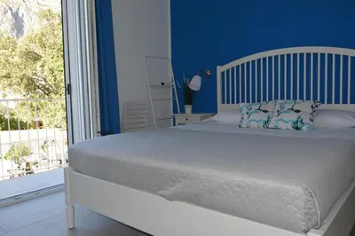a bedroom with a bed with blue walls and a window at I colori del mare in Macari