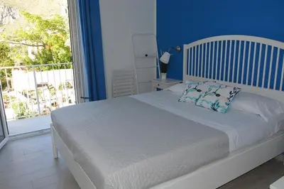 a bedroom with a bed with blue walls and a window at I colori del mare in Macari
