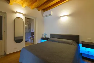 a bedroom with a bed and a chair in a room at Maquedino holiday home & Terrace - Cozy Central Loft in Palermo