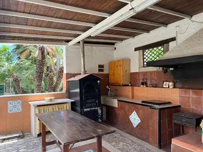 a kitchen with a stove and a wooden table at Villa Barone in Castellammare del Golfo