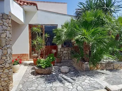 a courtyard with potted plants in front of a house at Villa Barone in Castellammare del Golfo