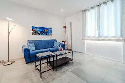 a living room with a blue couch and a table at AL BAYDA in Palermo