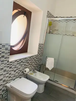 a bathroom with a toilet and a shower and a sink at Bonorum Santa Sofia in Palermo