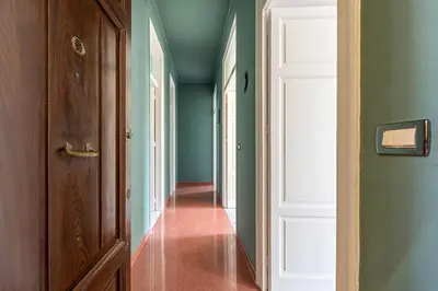 a hallway with green walls and a white door at Dante Design Apartment by Wonderful Italy in Palermo