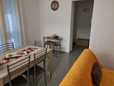 a dining room with a table and chairs and a clock on the wall at ADRIANA SEAHOUSE in Balestrate