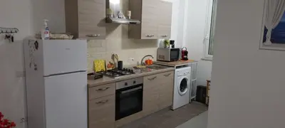 a kitchen with a white refrigerator and a washer and dryer at ADRIANA SEAHOUSE in Balestrate