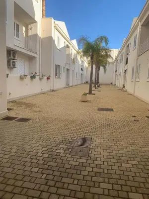 a cobblestone street with a palm tree and buildings at ADRIANA SEAHOUSE in Balestrate