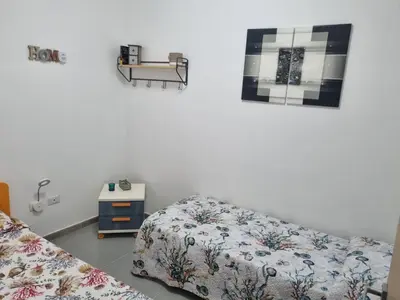 a bedroom with two beds and a table on the wall at ADRIANA SEAHOUSE in Balestrate