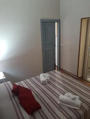 a bedroom with a bed with towels and a mirror at CASA VACANZA DI VIA GIACALONE in Palermo