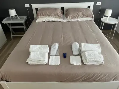 a bed with three white towels and two cups on it at Un Raggio di Sole al Massimo in Palermo
