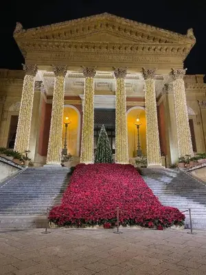 a large building with a large display of red flowers at Un Raggio di Sole al Massimo in Palermo