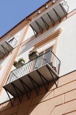 a building with two potted plants on a balcony at meloluxuryhouse in Palermo