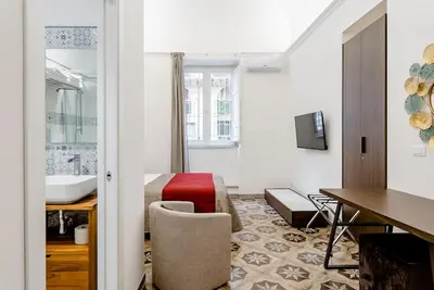 a hotel room with a table and a chair at Cortile Marconi Apartment in Palermo