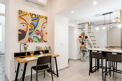 a kitchen and dining room with a painting on the wall at Cortile Marconi Apartment in Palermo